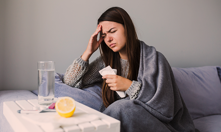 Fotografia de uma mulher adulta com sintomas de gripe - em Vacina da Gripe: tudo o que você precisa saber